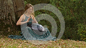 Playing The Instrument Hung. Woman Hands Playing The Hang outdoors.