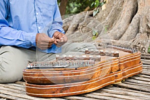 Playing a khim musical instrument, Cambodia