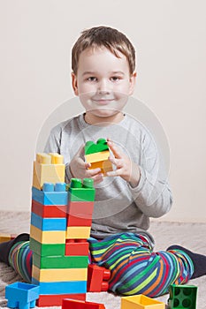 Playing little boy with colored cubes