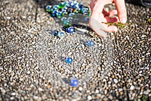 Playing marbles, old children`s game, colorful balls