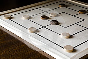 Playing mill game on a wooden table