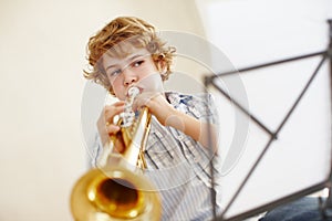 Playing, music and child with notes and trumpet for practice, jazz lesson and learning for talent show. Musician