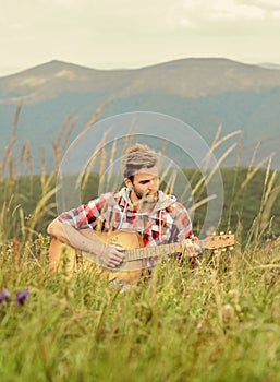 Playing music. Silence of mountains and sound of guitar strings. Hipster musician. Inspiring environment. Man musician