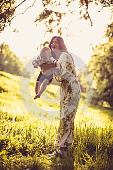 Playing at nature. Young mother and her baby boy.