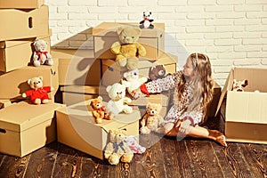 Playing into new home. new apartment. Cardboard boxes - moving to new house. happy little girl with toy. purchase of new