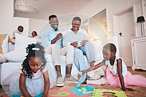 Playing, parents and children relax in living room for bonding, quality time and child development. Happy family, home