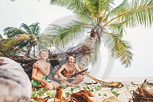 Playing in Robinzones: father and son built a hut from palm tree