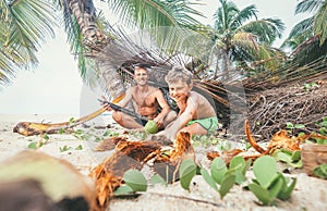 Playing in Robinzones: father and son built a hut from palm tree