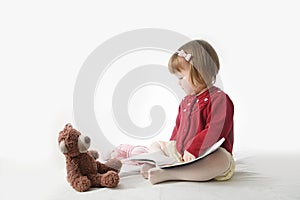 Playing school with toys. happy smiling baby girl elegant in dress. cute caucasian baby with teddy bear