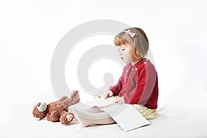 Playing school with toys. happy smiling baby girl elegant in dress. cute caucasian baby with teddy bear