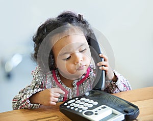 Playing, serious and a child on a telephone phone call for communication in a house. Home, contact and a girl, kid or