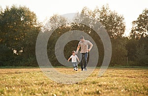 Playing soccer. Father and little son are having fun outdoors