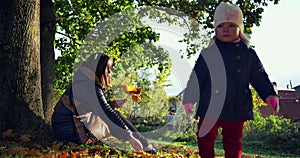 Playing Together in Autumn Park. Beautiful family in autumn park enjoying nature.