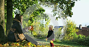 Playing Together in Autumn Park. Beautiful family in autumn park enjoying nature.
