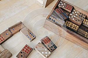 Playing traditional wooden domino game on wooden table background.Family board game, Game night vintage dominos in a row on old ru