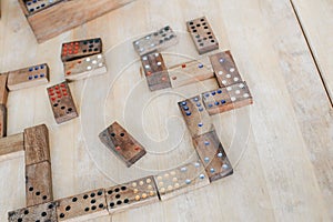 Playing traditional wooden domino game on wooden table background.Family board game, Game night vintage dominos in a row on old ru