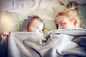 Playing under blanket with mommy. Little girl.