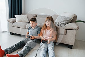 Playing videogames. Kids having fun in the domestic room at daytime together