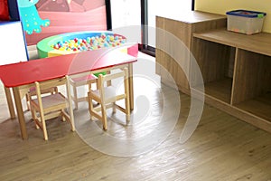 Playroom for children in a house with toys such as a kitchen, a table, a puppet theater, a ball pool, a piano and wood