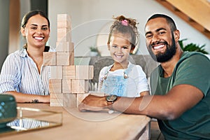 Playtime is fun for all. Portrait of a happy family playing with wooden blocks together at home.