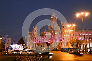 The Plaza de Cibeles at the intersection between Recoletos street and Alcala street, illuminated at sunset.