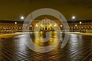 Plaza de EspaÃ±a in Seville, night scene after raining with long exposure photo and reflections of lights in water and cobbled