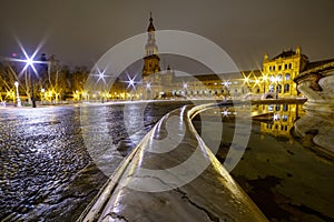 Plaza de EspaÃ±a in Seville, night scene after raining with long exposure photo and reflections of lights in water and cobbled