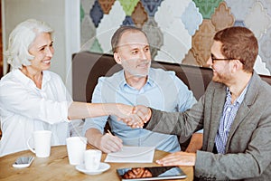 Pleasant aged couple meeting with sales manager