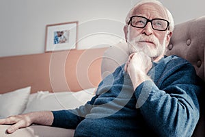 Pleasant aged man sitting at home