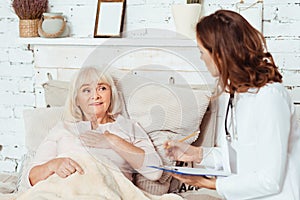 Pleasant aged woman lying in bed