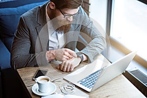Pleasant bearded man sitting at the table