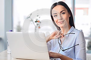 Pleasant business woman sitting at the table