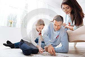 Pleasant caring father doing with his daughter a jigsaw puzzle