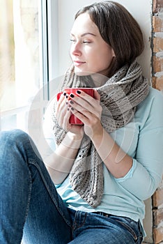 Pleasant cheerful woman enjoying view from the window