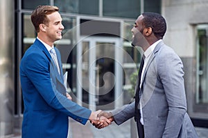 Pleasant colleagues shaking hands