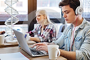 Pleasant concentrated student working as freelancer