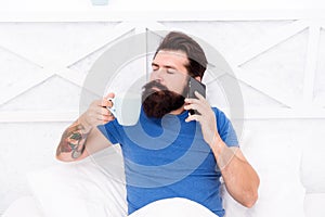 Pleasant conversation. Good morning. Hello dear. Bearded man using mobile technology in bed. Handsome guy talking on