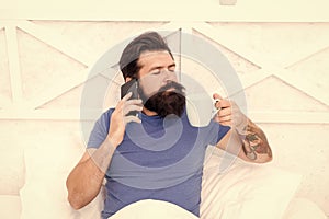 Pleasant conversation. Good morning. Hello dear. Bearded man using mobile technology in bed. Handsome guy talking on