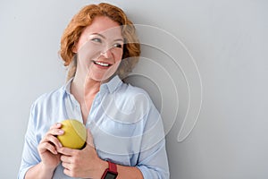 Pleasant delighted woman holding apple