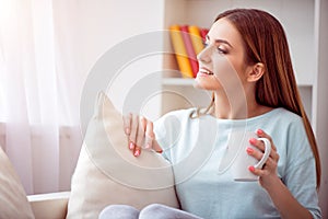 Pleasant delighted woman resting on the couch