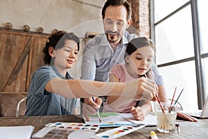 Pleasant family being immersed into painting process