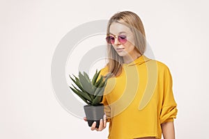 Pleasant female with a plant in hand