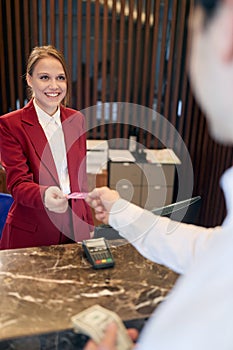 A pleasant female receptionist receiving the guests at the hotel. Tourism, business, hotel