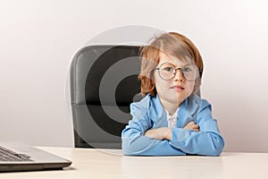 Pleasant ginger boy with sceptic expression looking at the camera