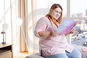 Pleasant good looking woman reading an article