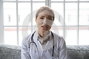 Pleasant happy young general practitioner holding video call with patient.