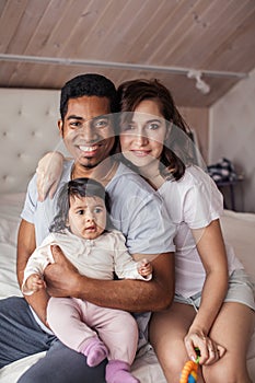 Pleasant mixed race couple taking care of their child