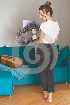 Pleasant moments of life. Young beautiful girl with a bouquet of flowers. Holiday, flowers as a gift. With grane.