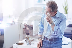 Pleasant nice man holding a paper tissue