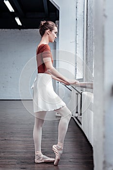 Pleasant nice woman standing at the barre